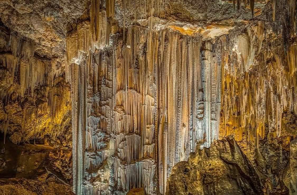 Impressive stalactites and stalagmites, warmly lit