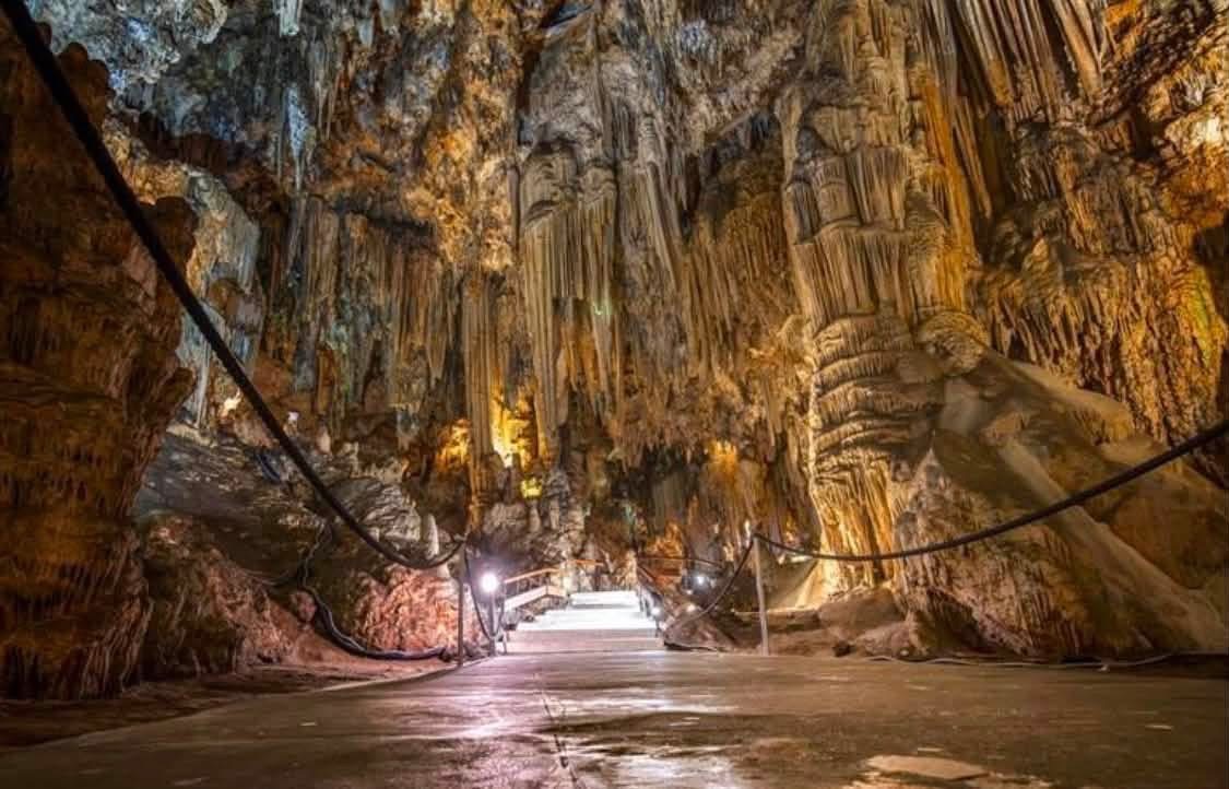 Illuminated cave with impressive formations of stalactites