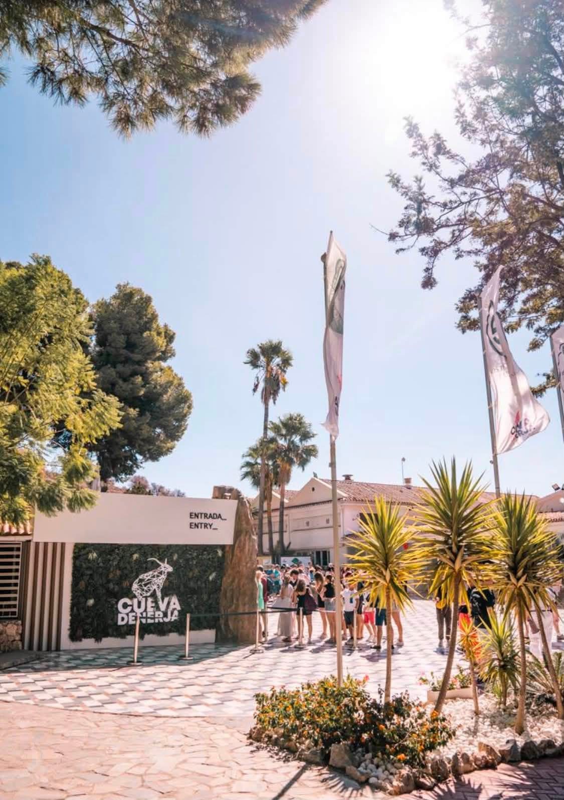 De ingang van de Cueva de Nerja met wachtende bezoekers en palmbomen