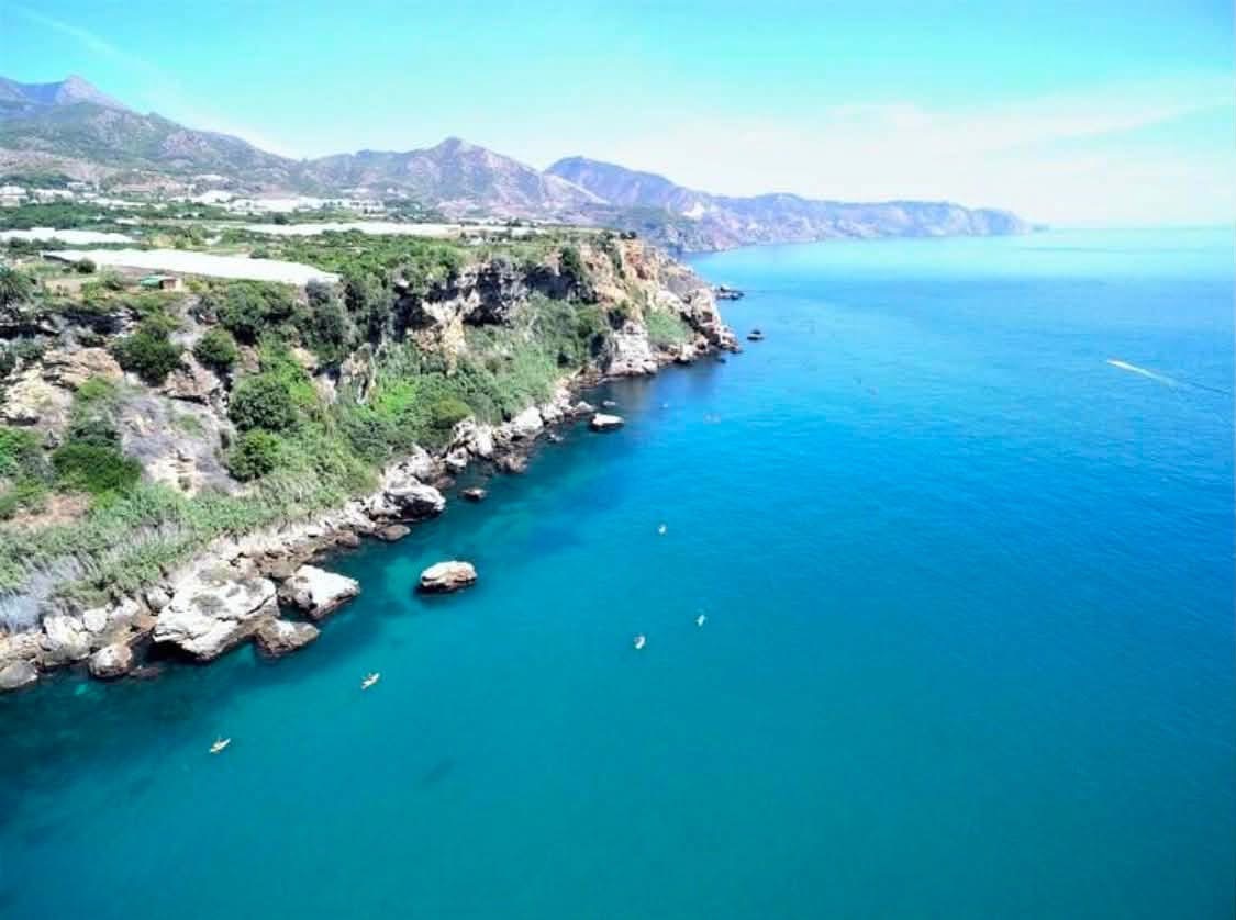 Blick aus der Luft auf die Küste von Nerja mit grünen
