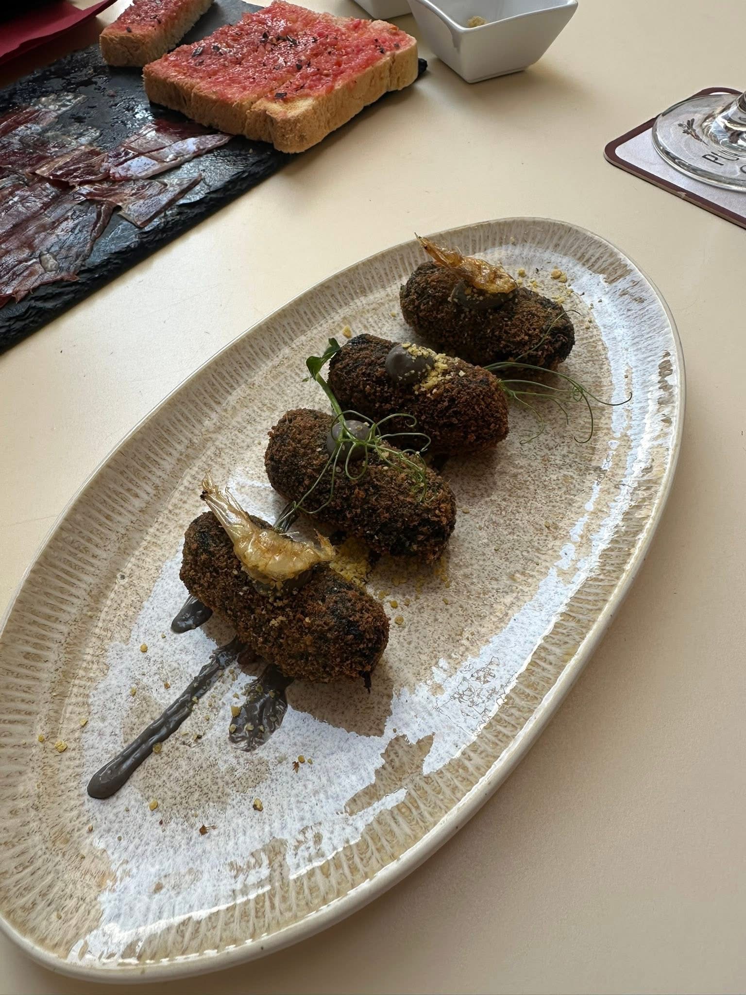 Croquetas fritas con gambas en un plato alargado