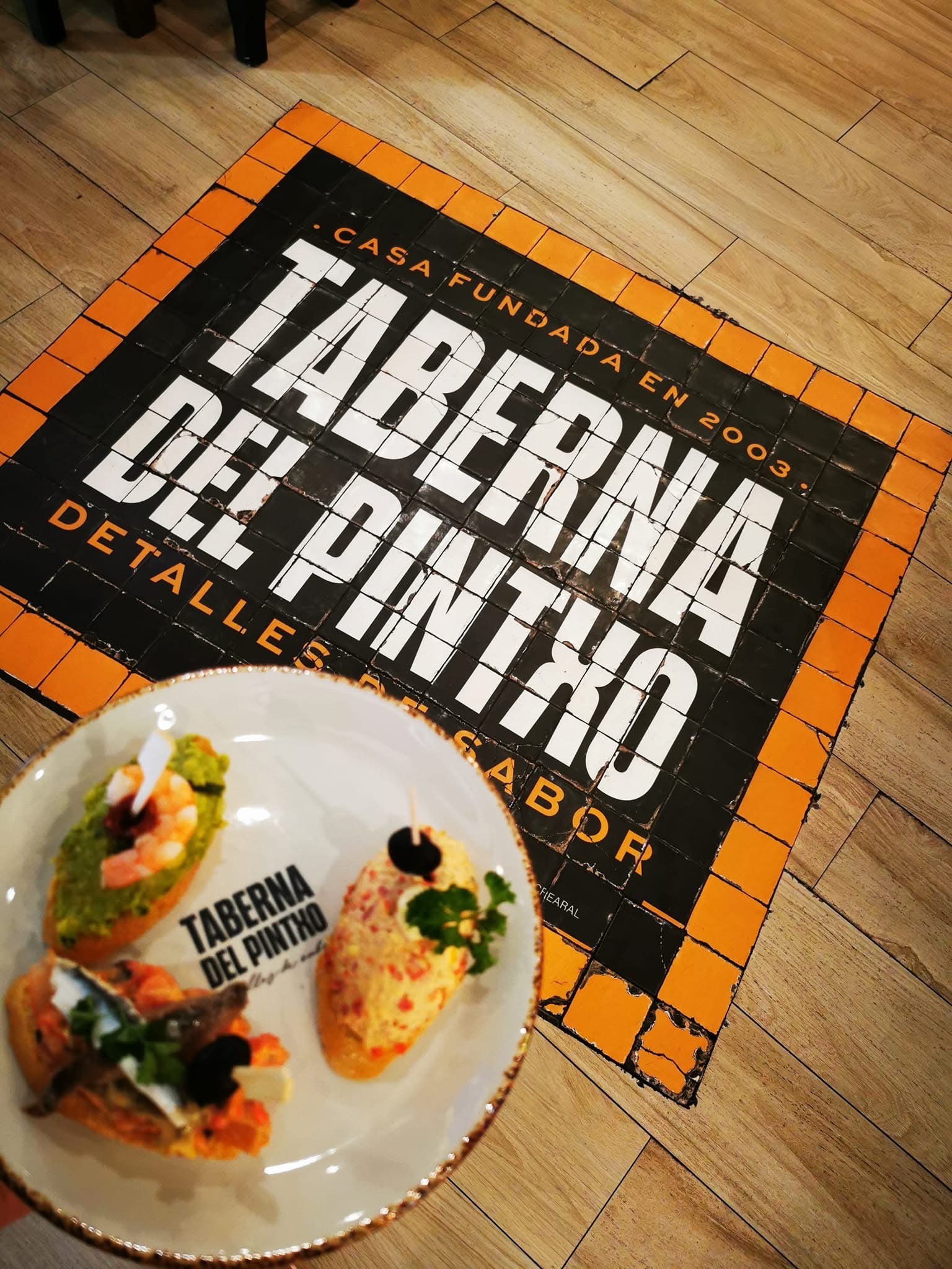 Tres pinchos coloridos en un plato delante de un suelo