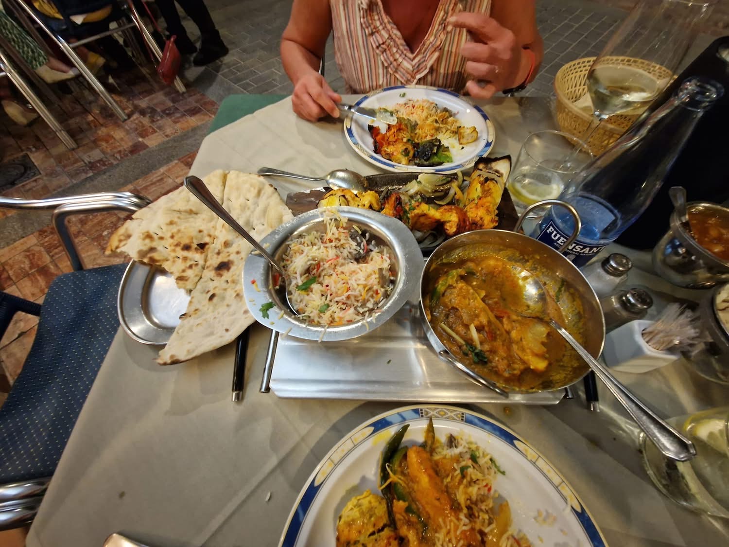 A table filled with various Indian dishes, including naan