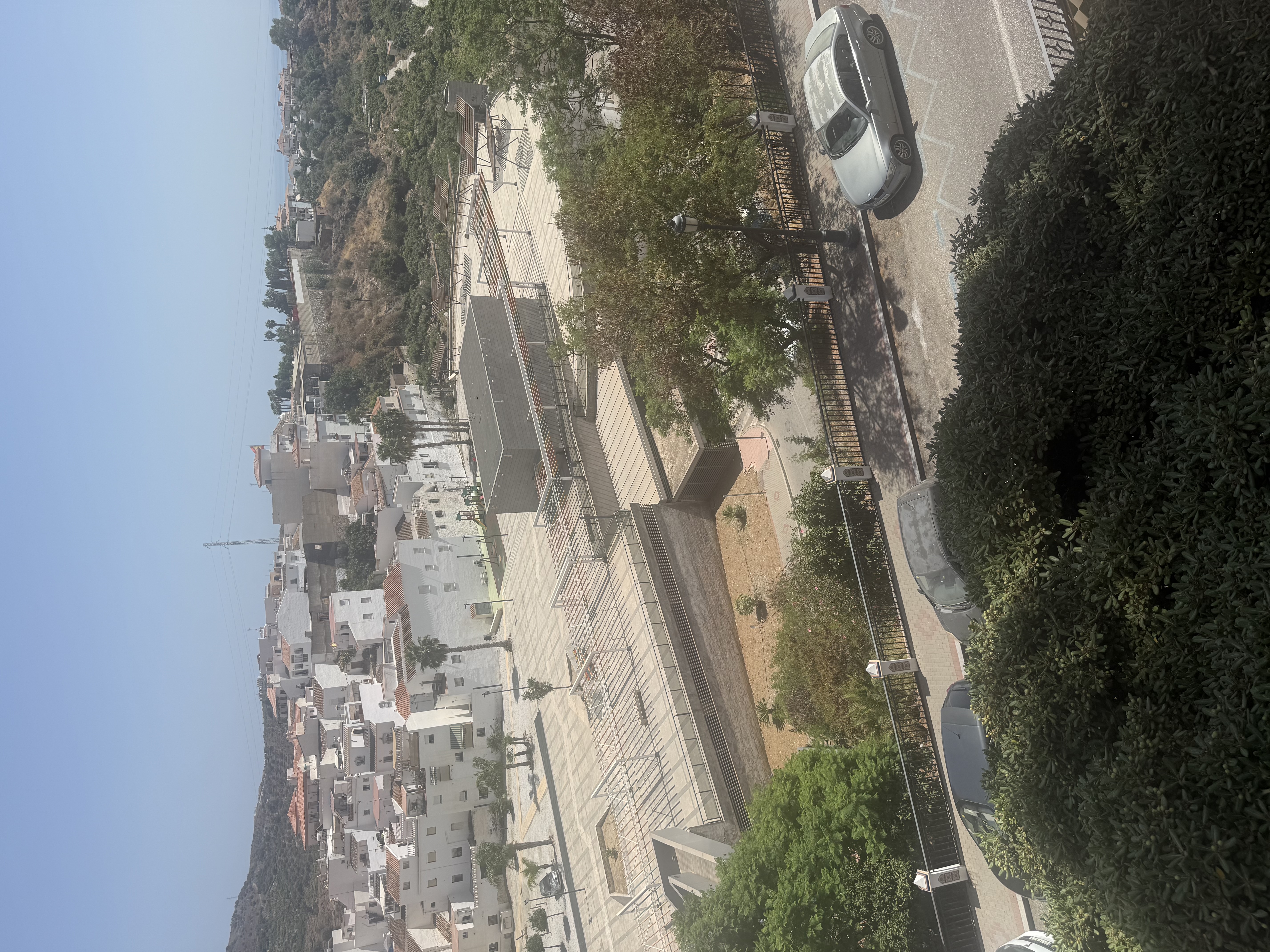 Overhead view of white houses, modern square, and parked