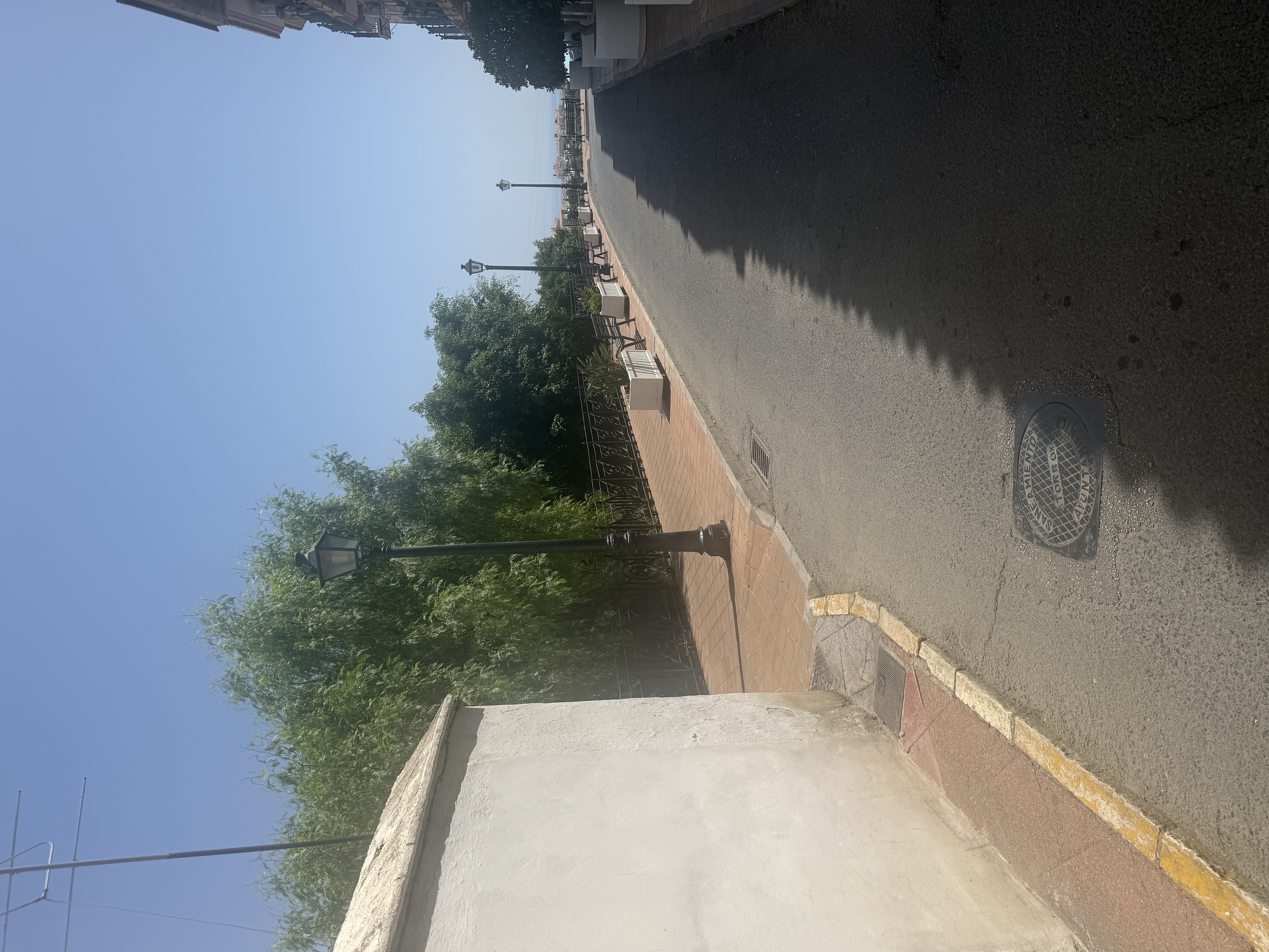 Solig gata med strandpromenad och havsutsikt i Nerja